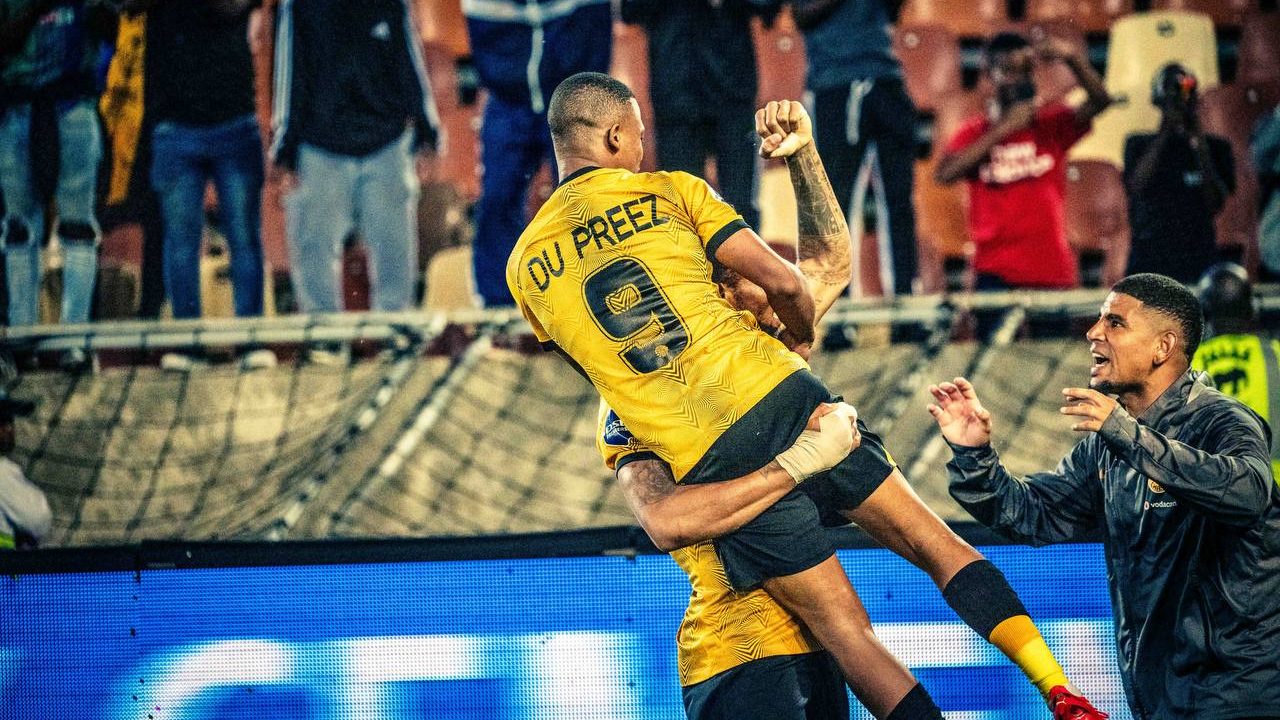 Kaizer Chiefs striker Ashley Du Preez celebrating with teammates after scoring against Royal AM at Peter Mokaba Stadium.