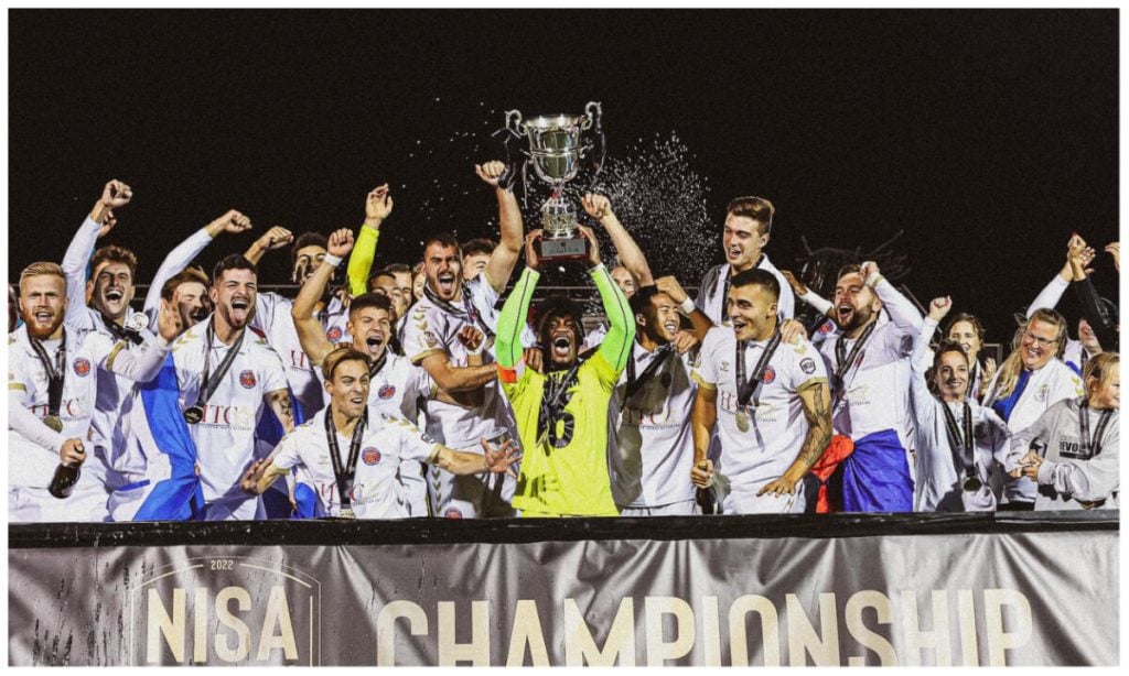 Tatenda Mkuruva in the middle holding the trophy in celebration