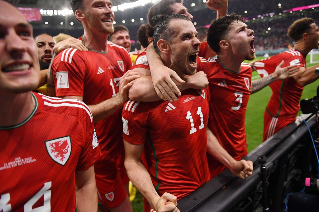 Gareth Bale celebrates with teammates after scoring the equaliser against the USA at the 2022 FIFA World Cup Qatar