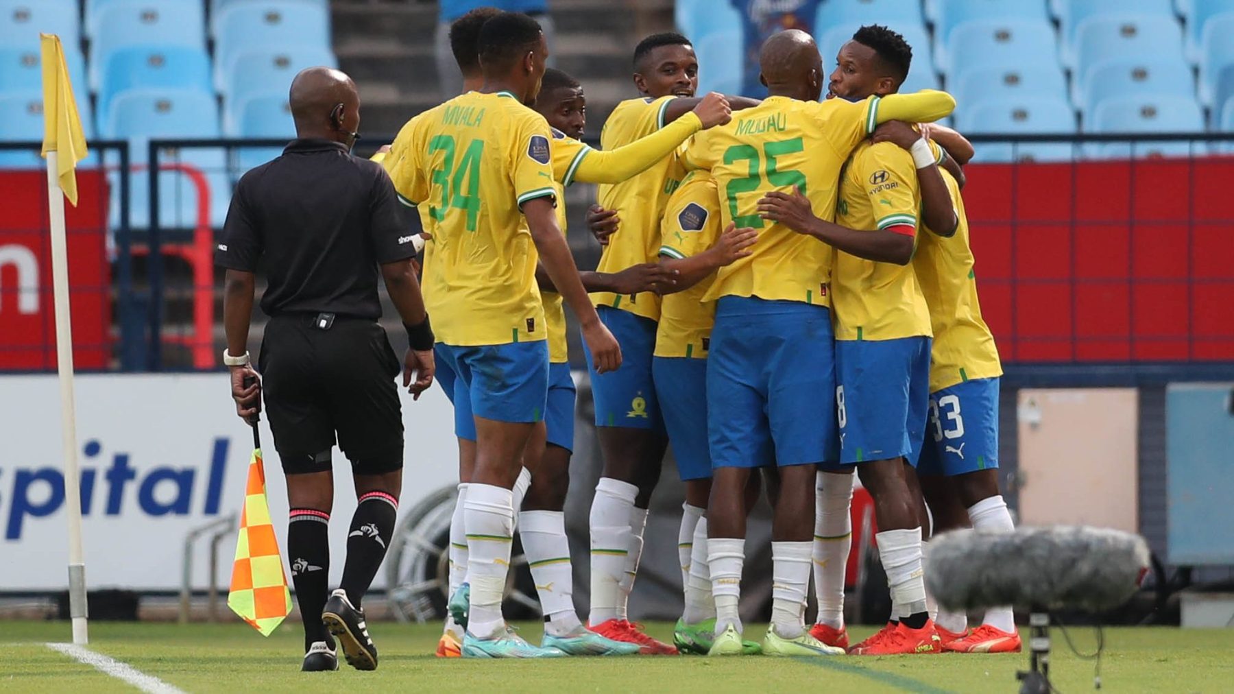 Mothobi Mvala celebrating a goal with teammates while Rulani Mokwena stands on the sideline