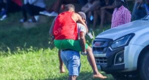 eSwatini Premier League club official carries a player to a private vehicle