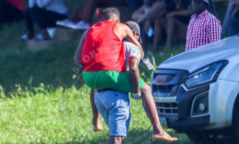 eSwatini Premier League club official carries a player to a private vehicle