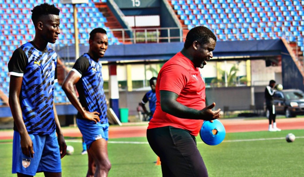 Liberia coach Ansu Keita with two of his players