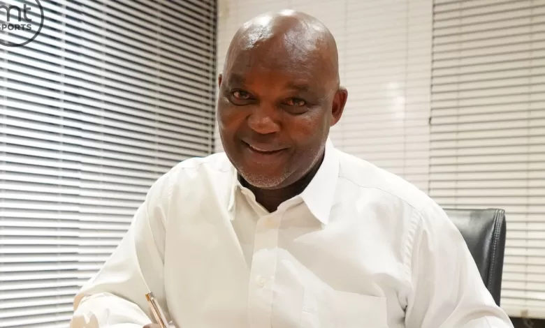 Pitso Mosimane putting pen to paper.