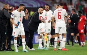 Walid Regragui with Morocco players on the sidelines during a match