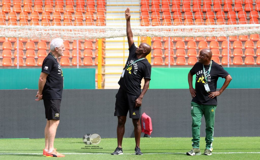 Helman Mkhalele with Bafana Bafana coach Hugo Broos and a staff member