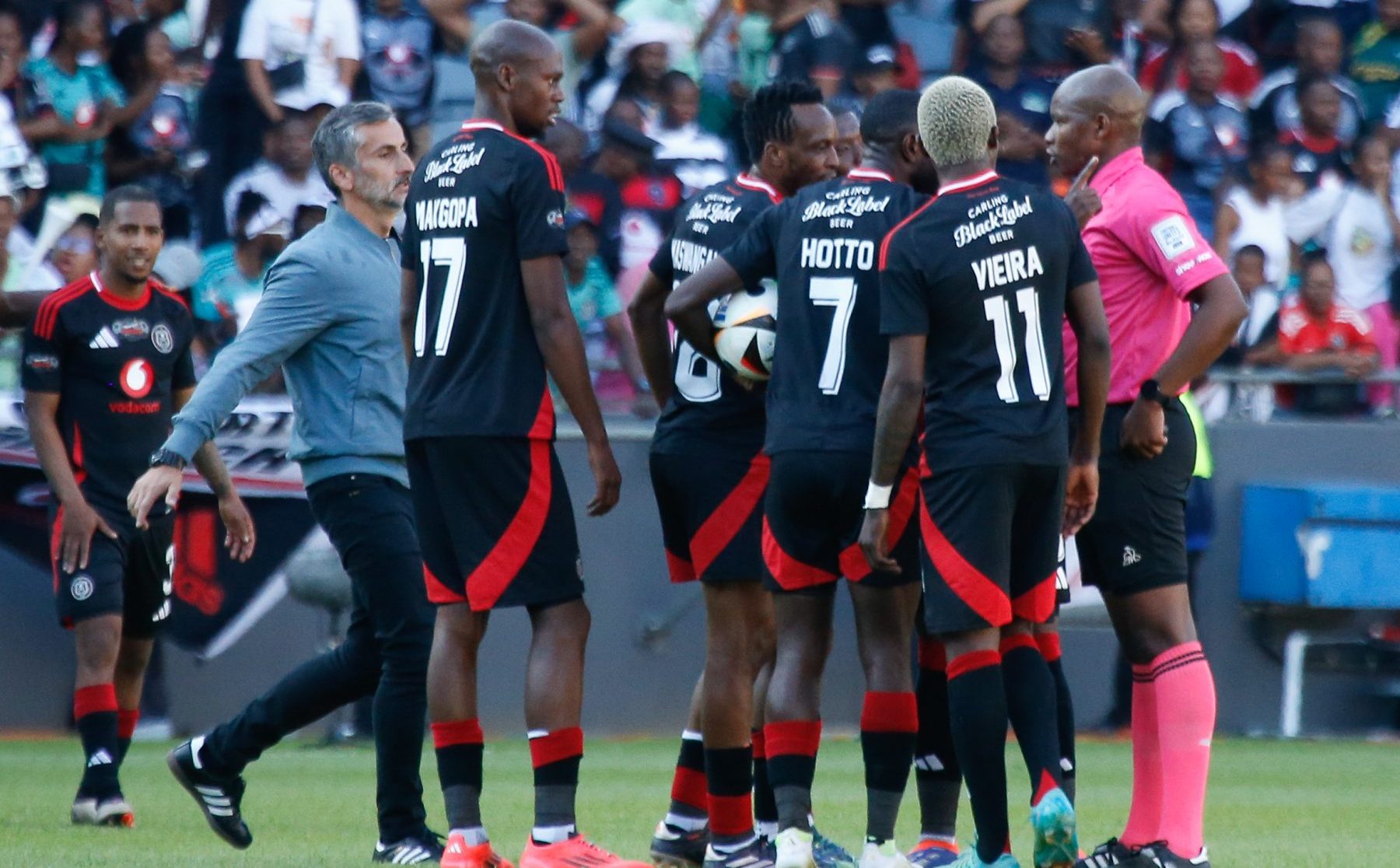 The unhappy Orlando Pirates players with the referee alongside Jose Riveiro