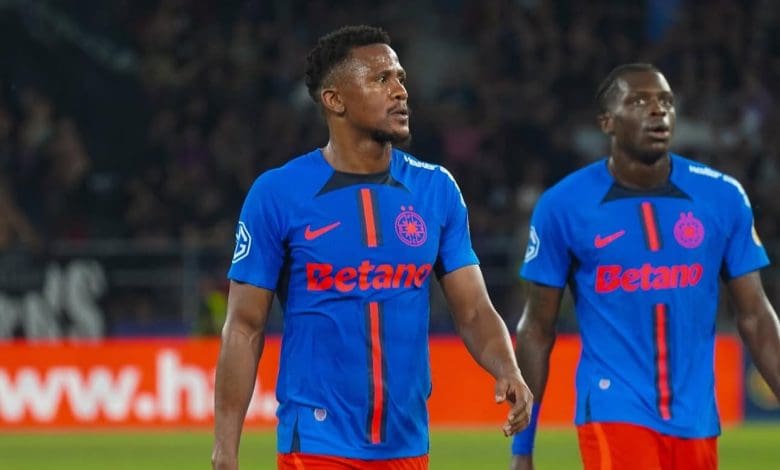 FCSB defender Siyabonga Ngezana and teammate walking in the pitch