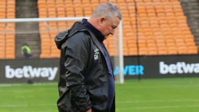 Coach Gavin Hunt walking on the pitch before a SuperSport United game