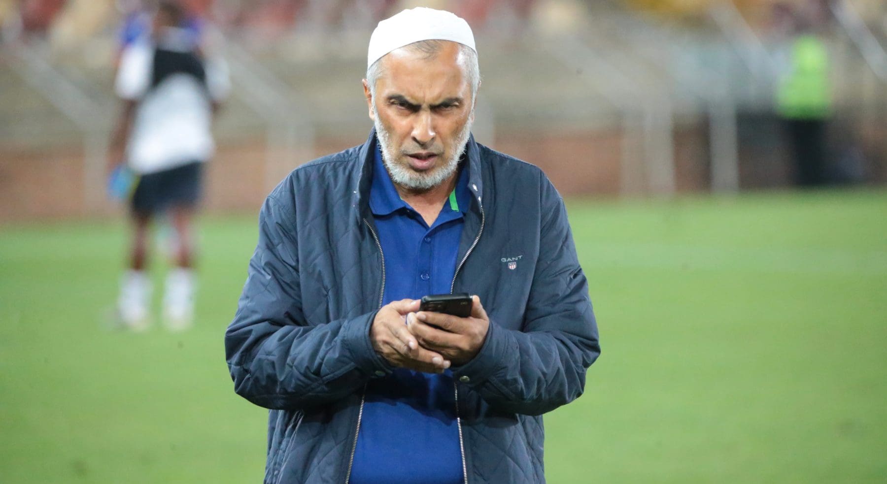 Durban City FC chairman Farouk Kadodia looking at his phone after a League match 