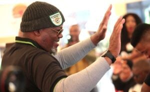 Khurishi Mphahlele waving his hands at a gathering in Seshego