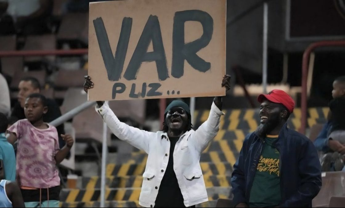 A fan carrying a message in support of the implementation of VAR at a soccer match