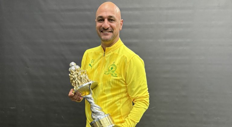 Goolam Valodia holding an African Football League trophy