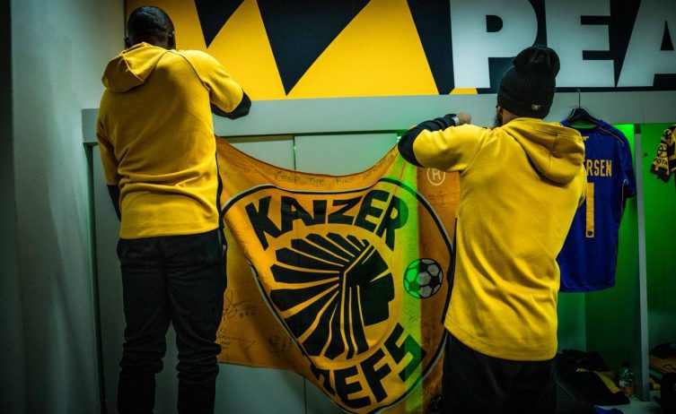 Kaizer Chiefs players putting up a club flag in the changing room