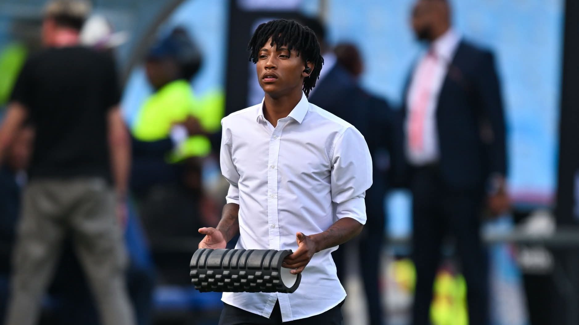 TS Galaxy midfielder Puso Dithejane holding a speaker during a match inspection