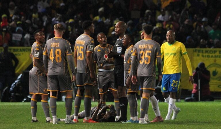 Kaizer Chiefs players surrounding Mduduzi Shabalala after sustaining an injury against Mamelodi Sundowns