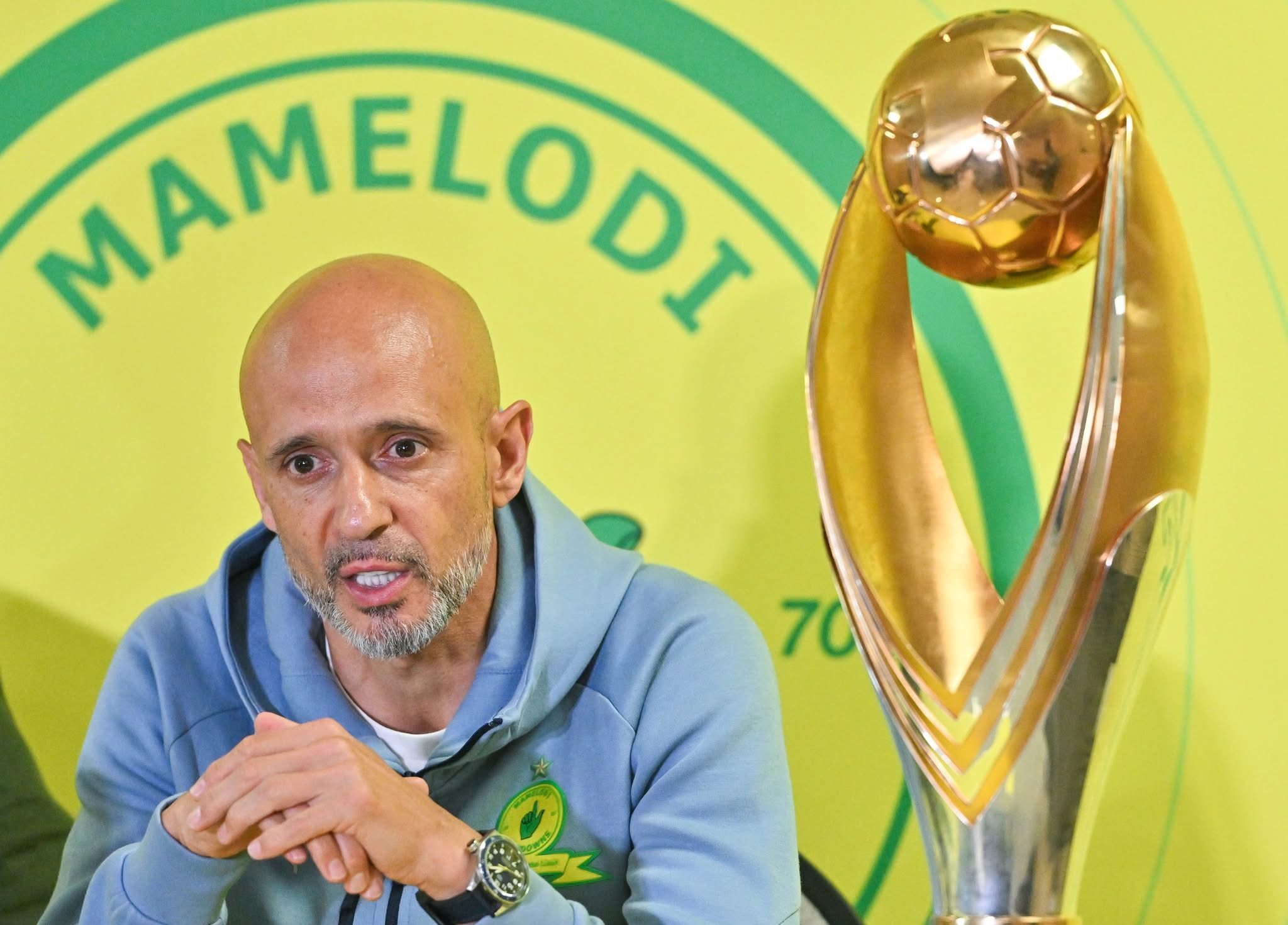 Miguel Cardoso pictured next to the CAF Champions League trophy.
