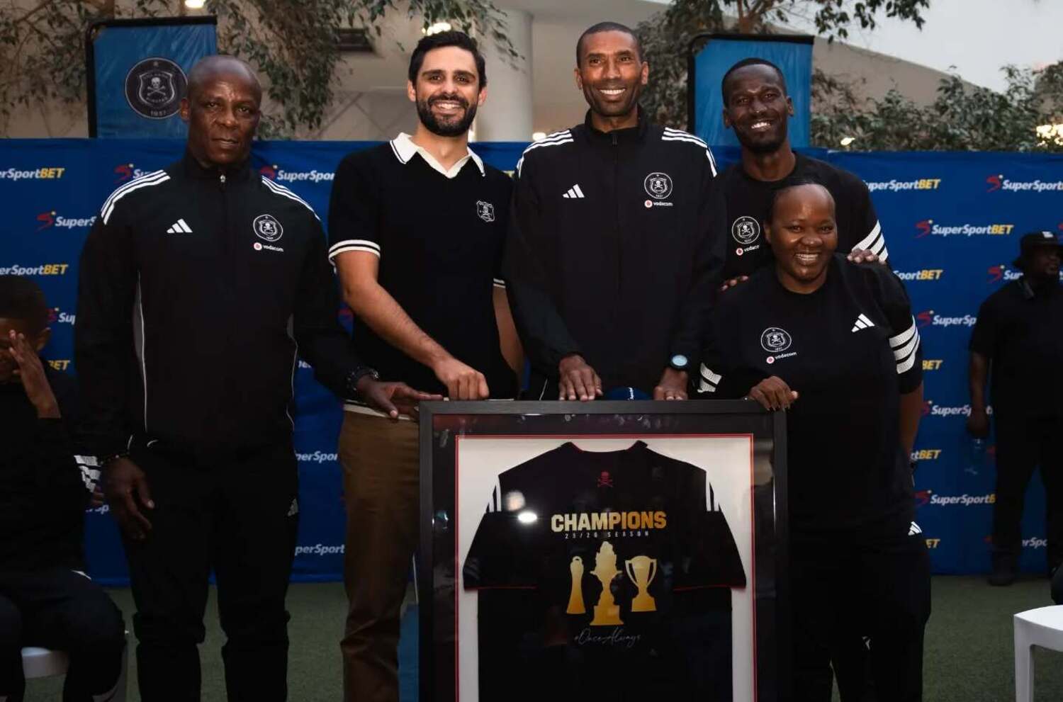 Mandla Ncikazi, Abdeslam Ouaddou and Tapelo Xoki with a framed shirt at the Orlando Pirates trophy parade.