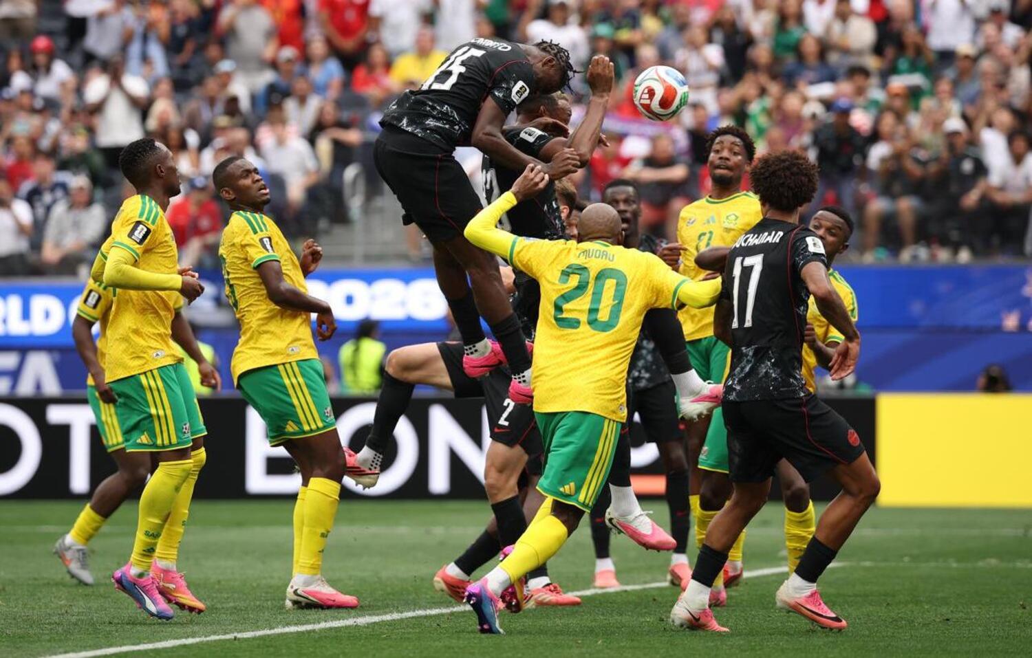 Moise Bombito of Canada heading in the ball against Bafana Bafana