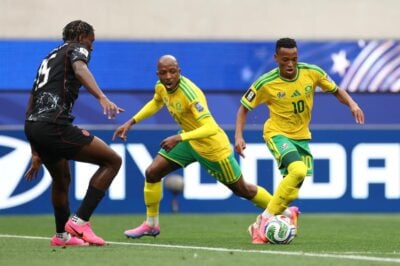 Bafana Bafana midfielder Relebohile Mofokeng dribbling past Canada star Moise Bombito with Khuliso Mudau in the background