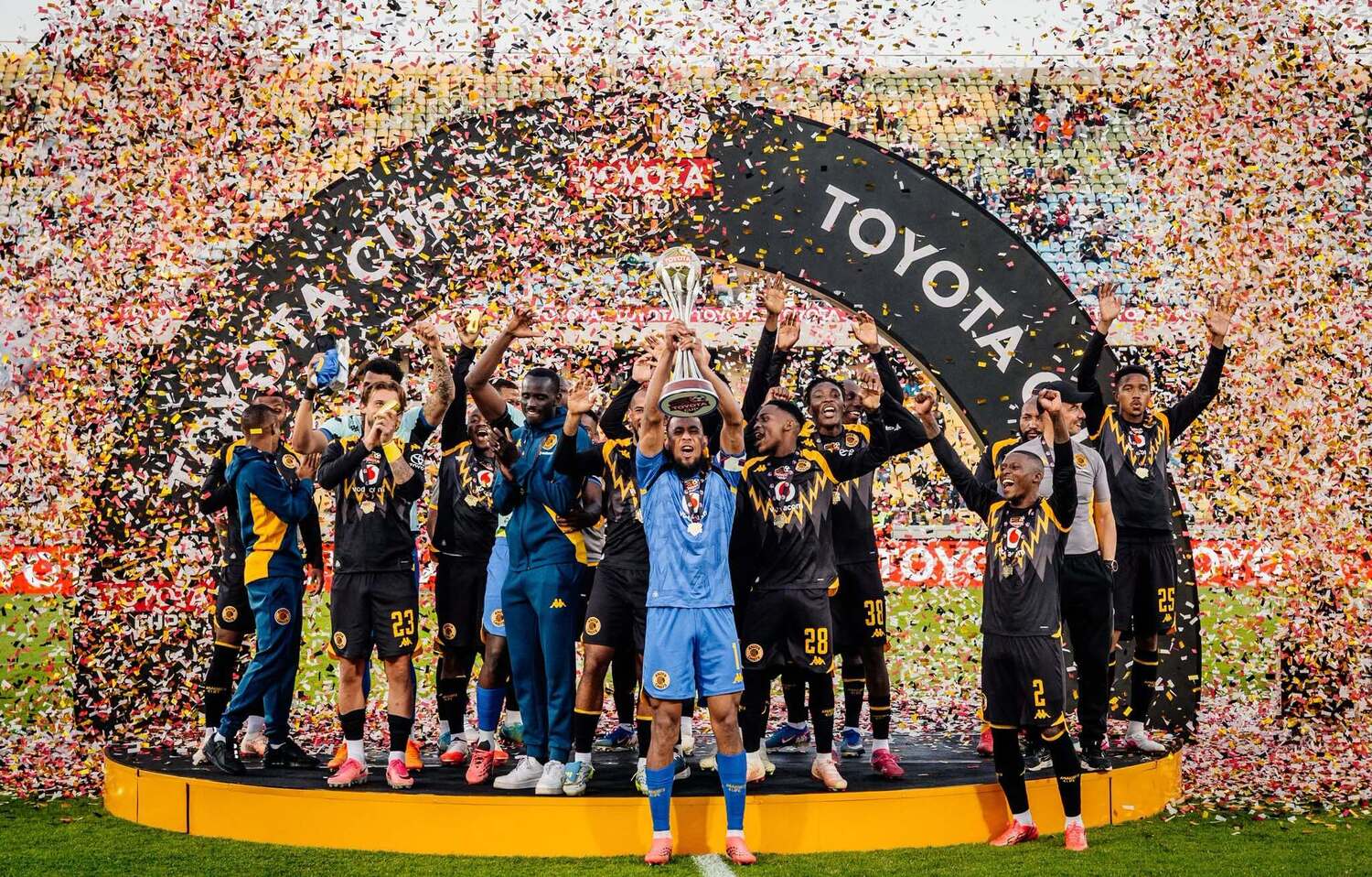 Brandon Petersen lifts the Toyota Cup as Kaizer Chiefs players and Fernando da Cruz celebrate