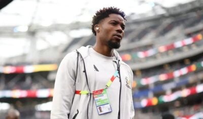 Ime Okon walking during a pitch inspection at the 2026 FIFA World Cup.