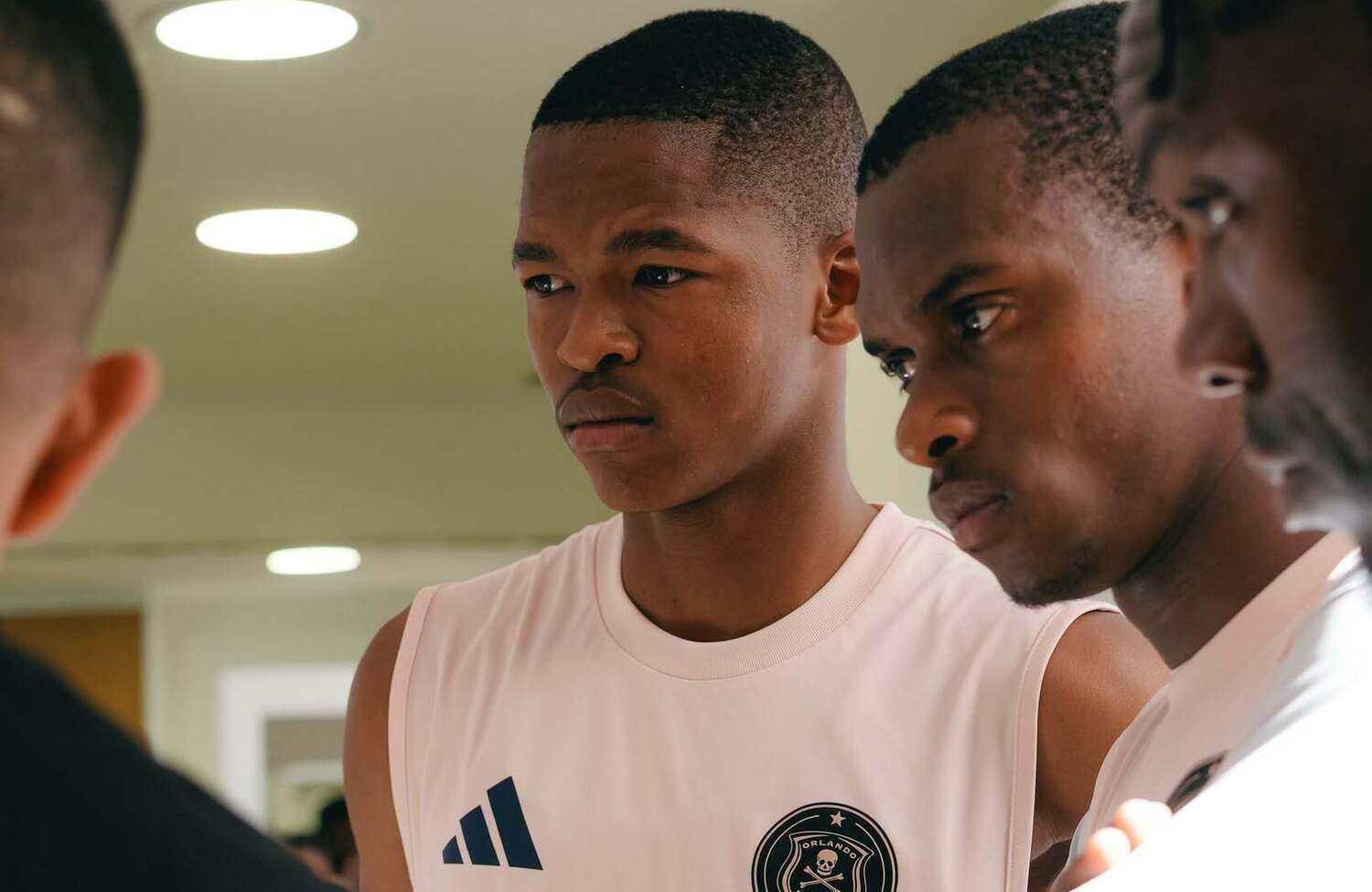 Mpho Padime and Nkosikhona Ndaba attentively follow an Orlando Pirates tactical talk