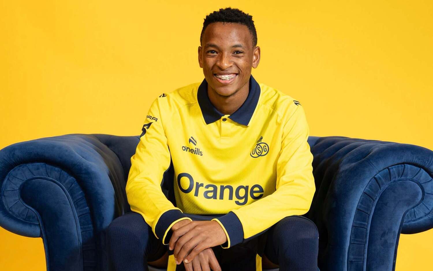 Relebohile Mofokeng sitting on a couch after being unveiled by Royale Union Saint-Gilloise