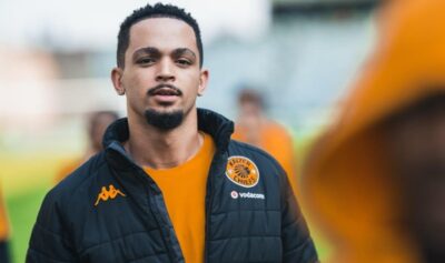 Aden McCarthy looking at the camera while doing a pitch inspection with Kaizer Chiefs