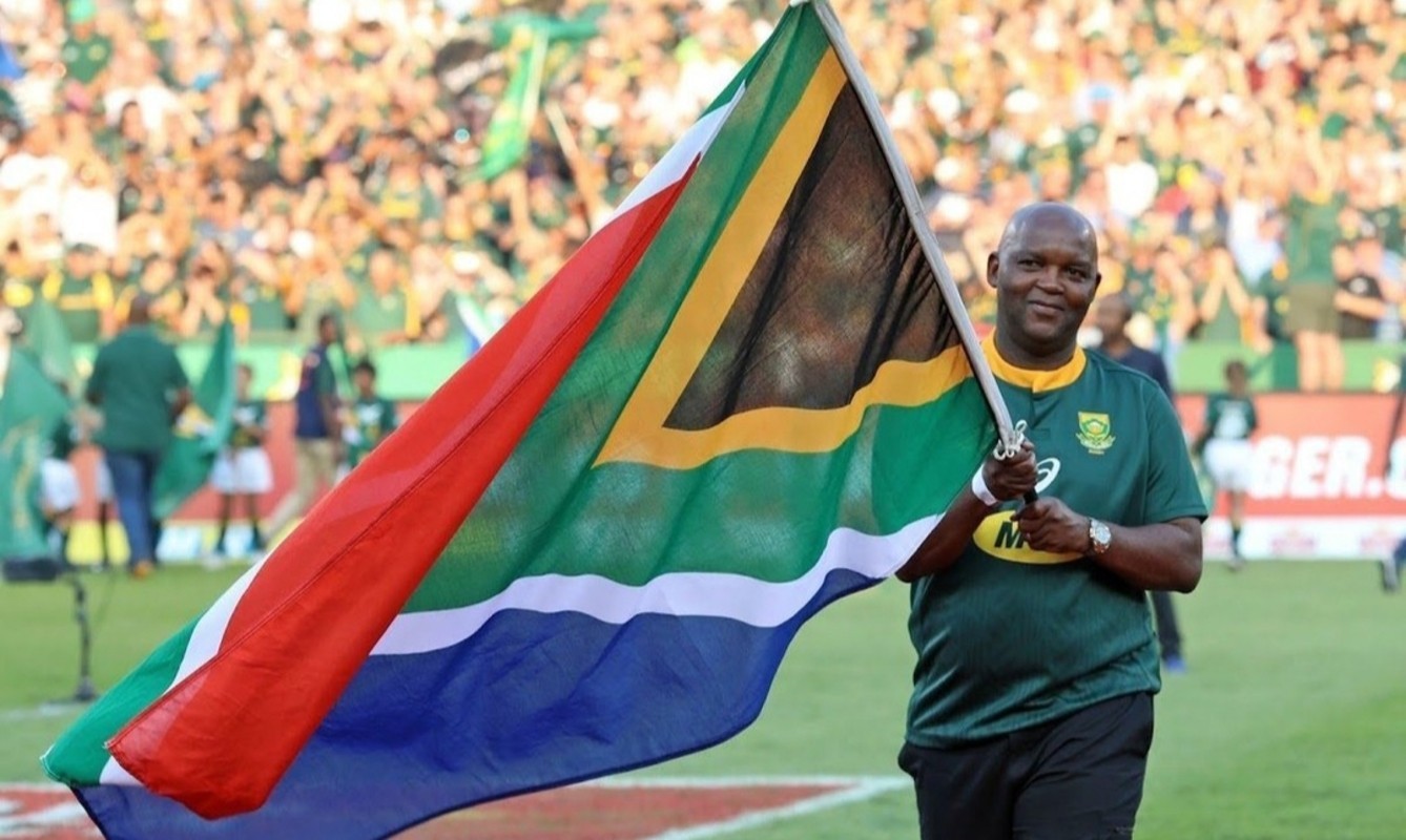 Pitso Mosimane carrying the South African flag before a Rugby match