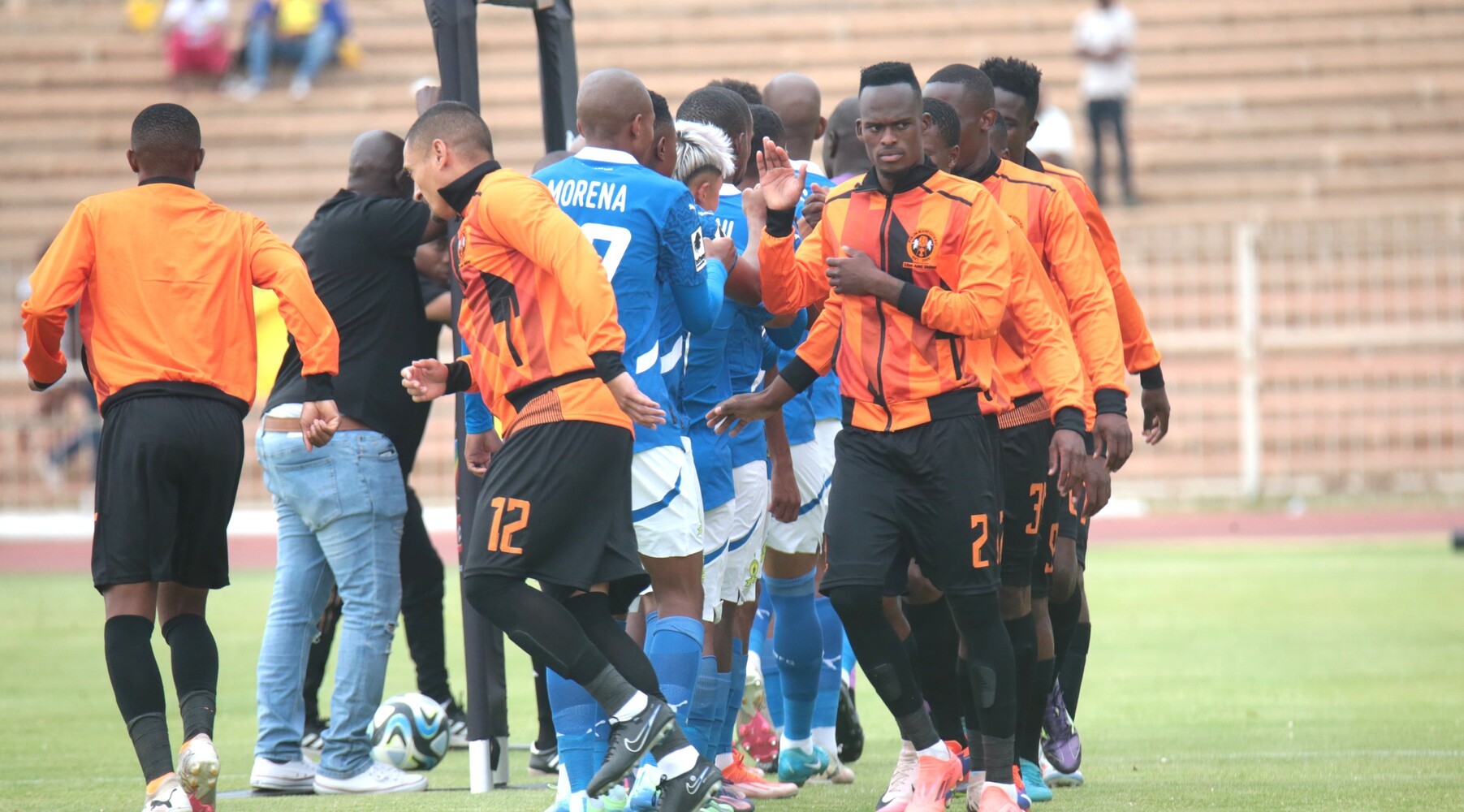 Thabang Matuludi greeting Mamelodi Sundowns players before a match.