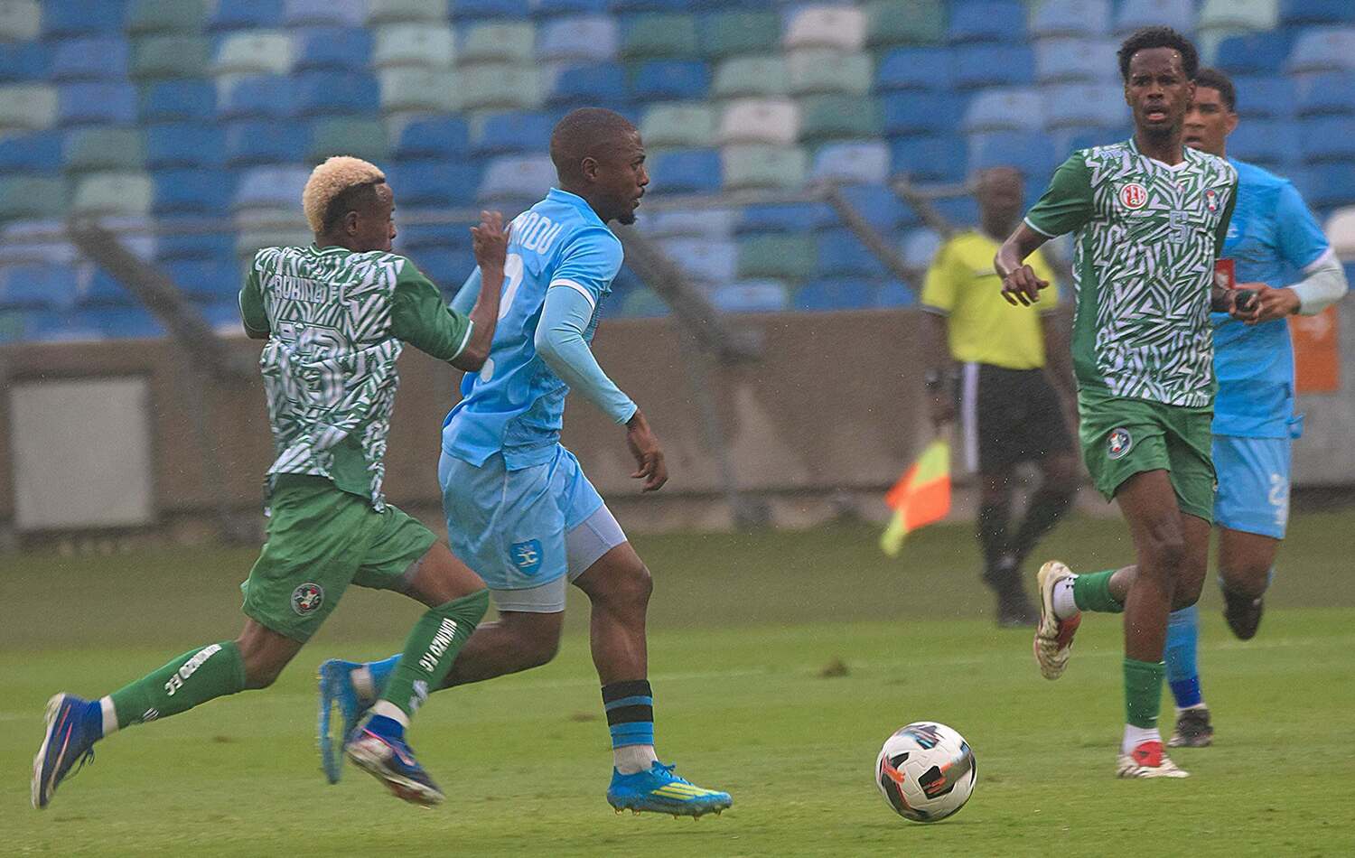 Durban City right-back Bandile Shandu dribbles the ball past Rukinzo FC players