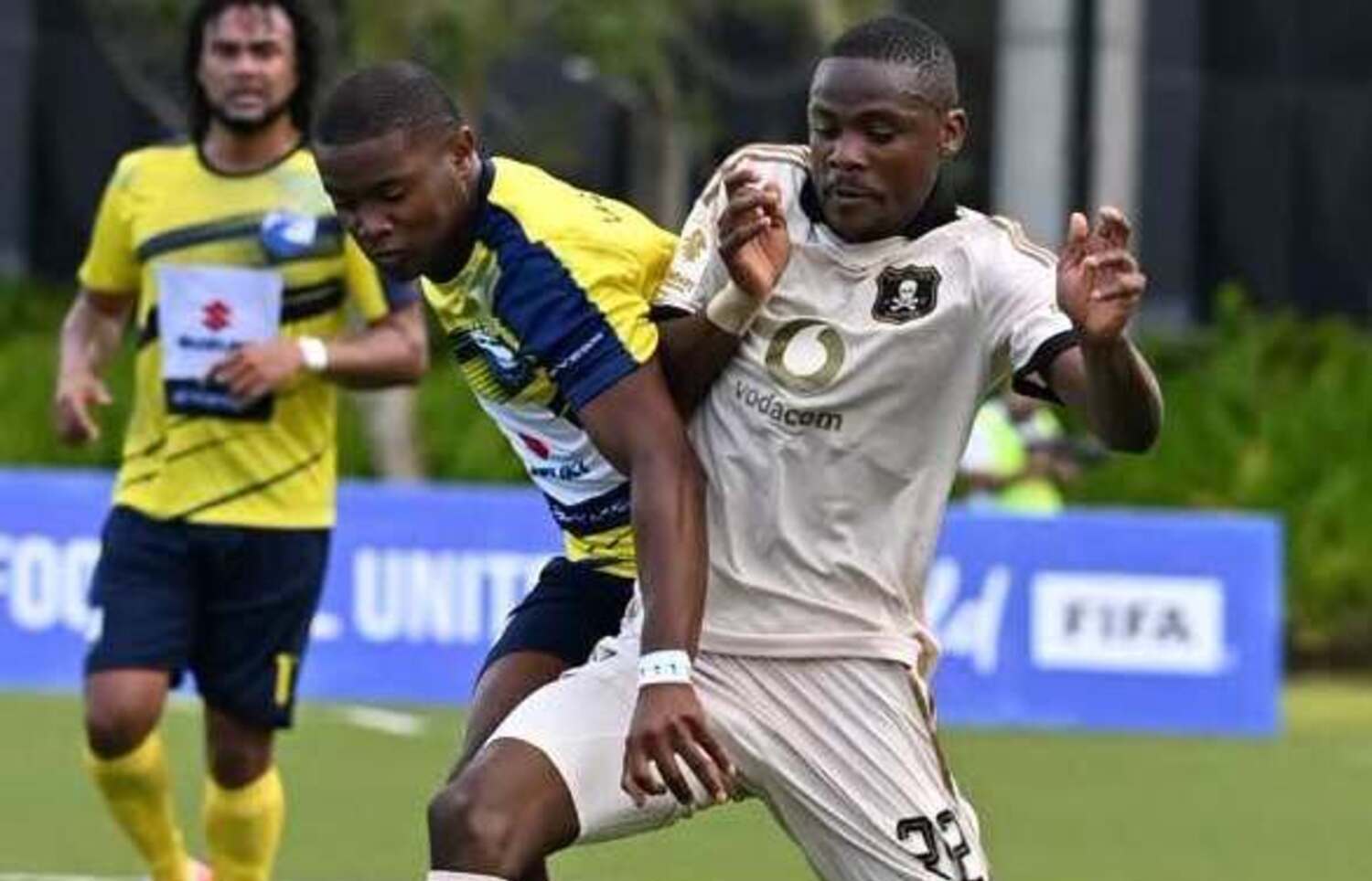 Orlando Pirates winger Daniel Msendami being challenged by a La Cure Waves player